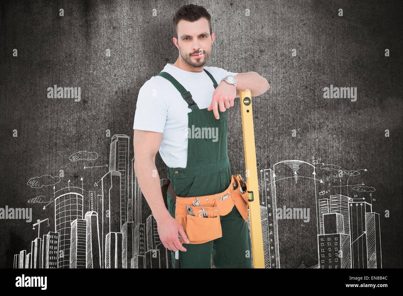 Composite image of carpenter smiling to camera with spirit level Stock Photo