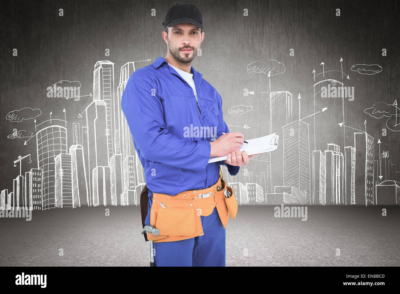 Composite image of handyman in blue overall writing on clipboard Stock Photo