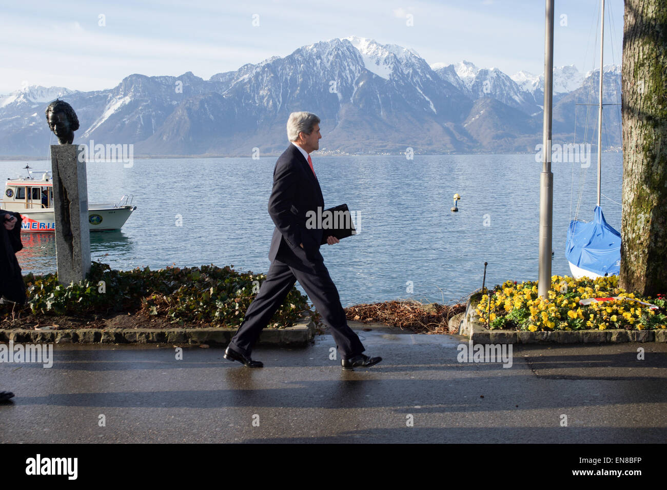 U.S. Secretary of State John Kerry passes a statue of jazz legend Miles Davis on March 3, 2015, as he walks along Lake Geneva in Montreux, Switzerland, scene of the annual Montreux Jazz Festival, before resuming negotiations with Iranian Foreign Minister Javad Zarif about the future of his country's nuclear program. Stock Photo