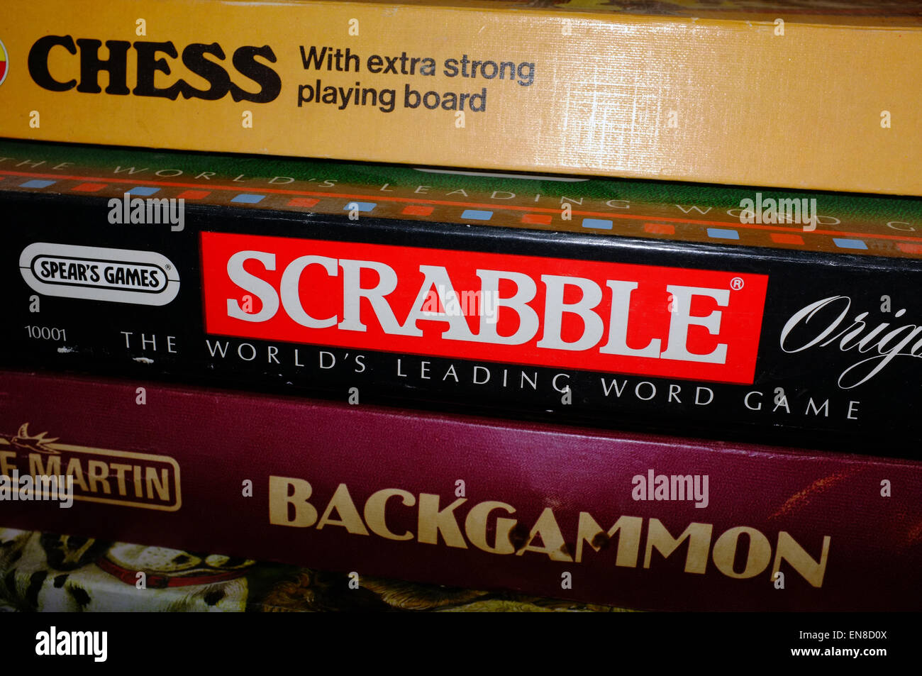 A pile of boardgames boxes including Chess, Scrabble and Backgammon in a Welsh B&B. Stock Photo