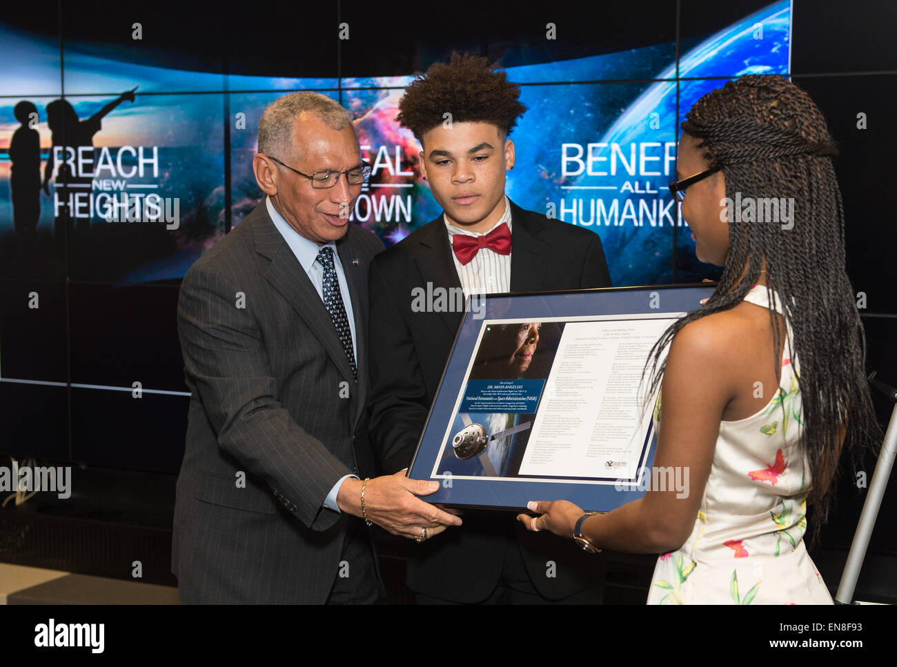 NASA Administrator Charles Bolden, left, accepts the gift of a portion of the writings of Dr. Maya Angelou that were flown aboard the Orion spacecraft during EFT-1 in December of 2014 from her great grandchildren, Brandon Johnson, center, and Caylin Johnson, right, during a ceremony on Monday, April 6, 2015 at NASA Headquarters in Washington, DC. Stock Photo