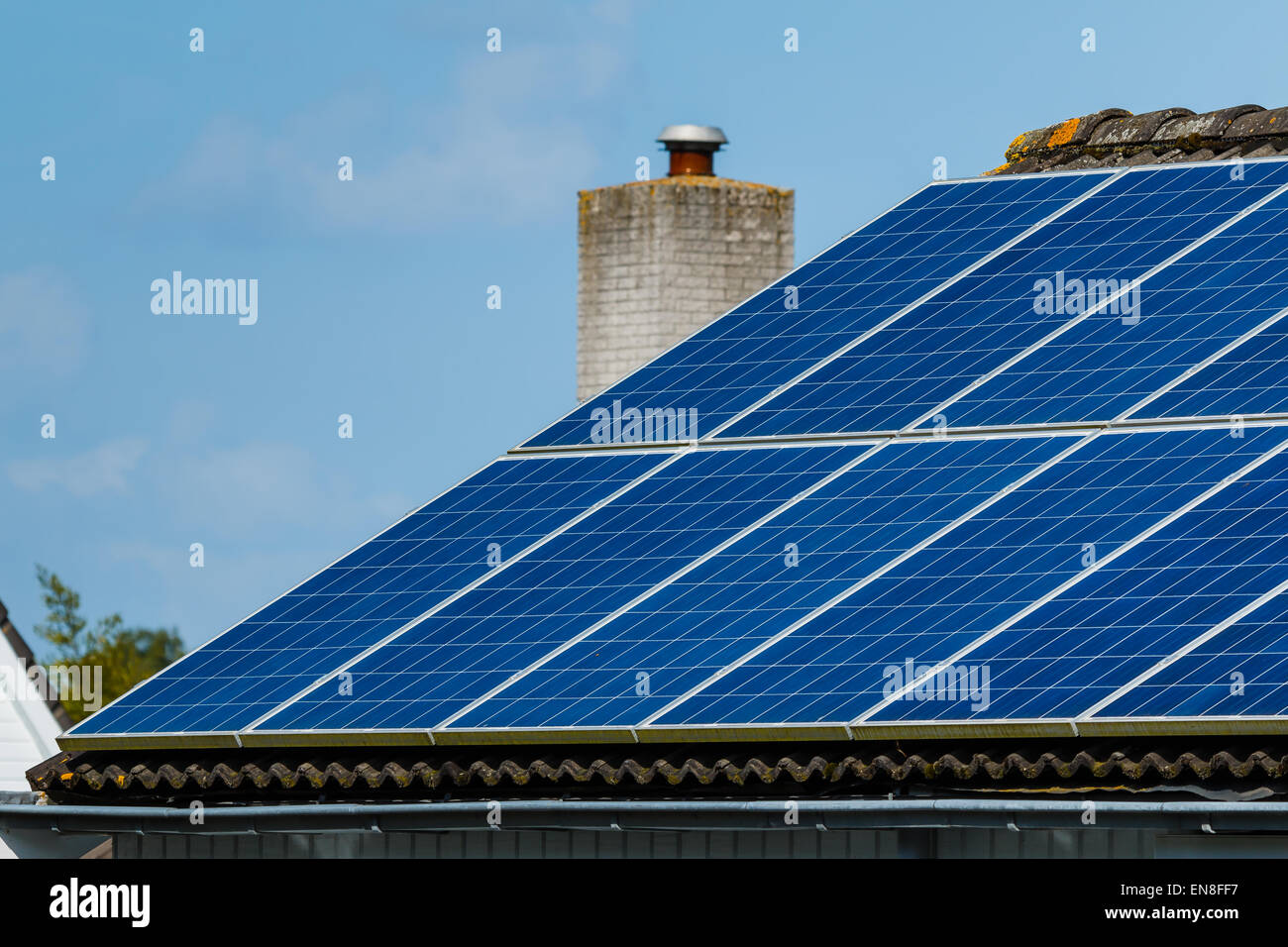 Solar panels on roof of a house generating electricity. Sustainable green energy. Stock Photo