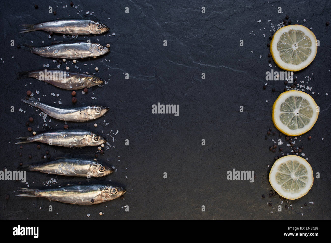 Small fishes with lemon on the table Stock Photo