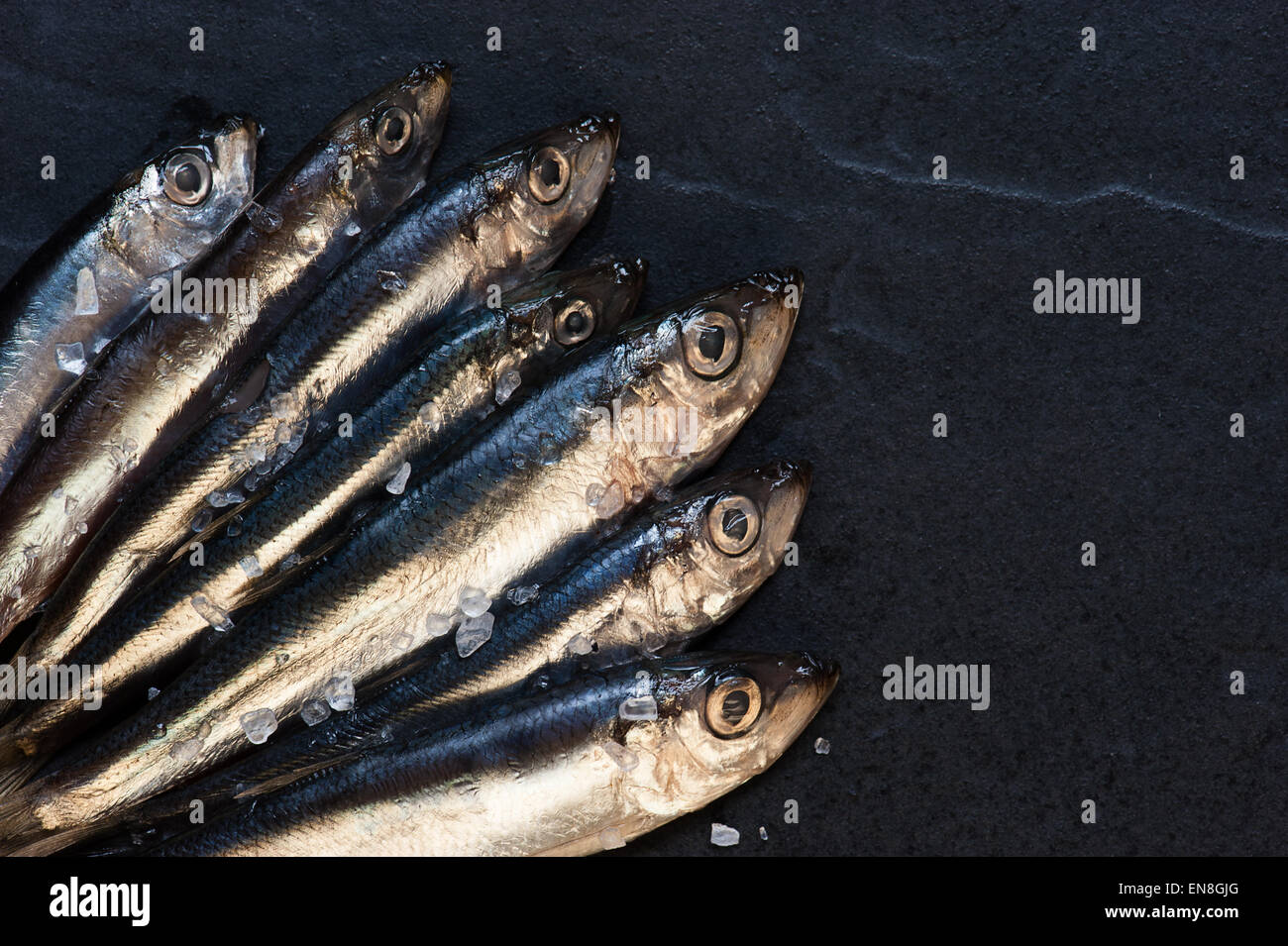 Small fishes with salt on the table Stock Photo