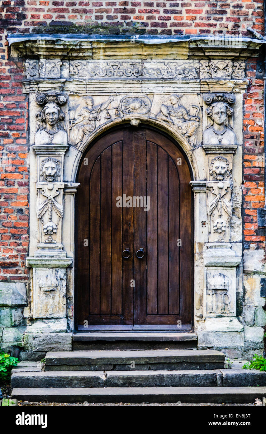 Medieval roundarched doorway, dark wooden double doors, elaborate