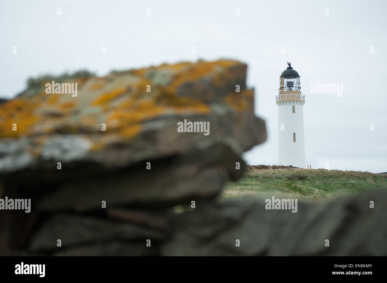Mull of Galloway lighthouse standing tall with rock in the foreground Stock Photo