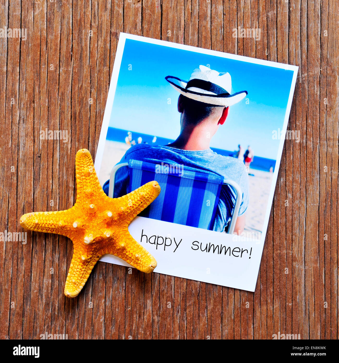 high-angle shot of a starfish and an instant photo, shot by myself, of a young man at the beach, with the text happy summer writ Stock Photo