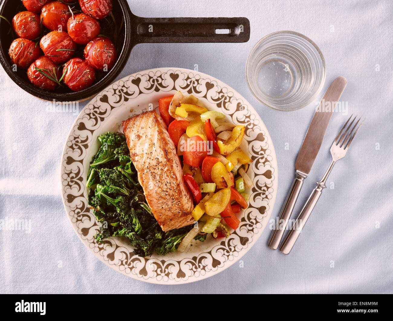 Food on dinner plate, roast salmon and crispy kale and other vegetables
