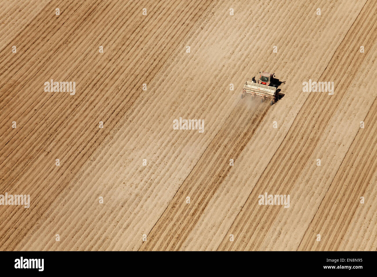 An aerial view of farm machinery planting potatoes in the fertile farm fields of Idaho. Stock Photo