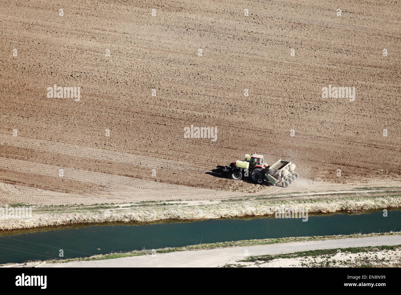 An aerial view of farm machinery planting potatoes in the fertile farm fields of Idaho. Stock Photo