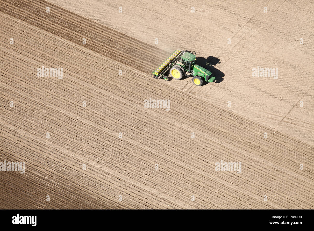 An aerial view of farm machinery planting potatoes in the fertile farm fields of Idaho. Stock Photo