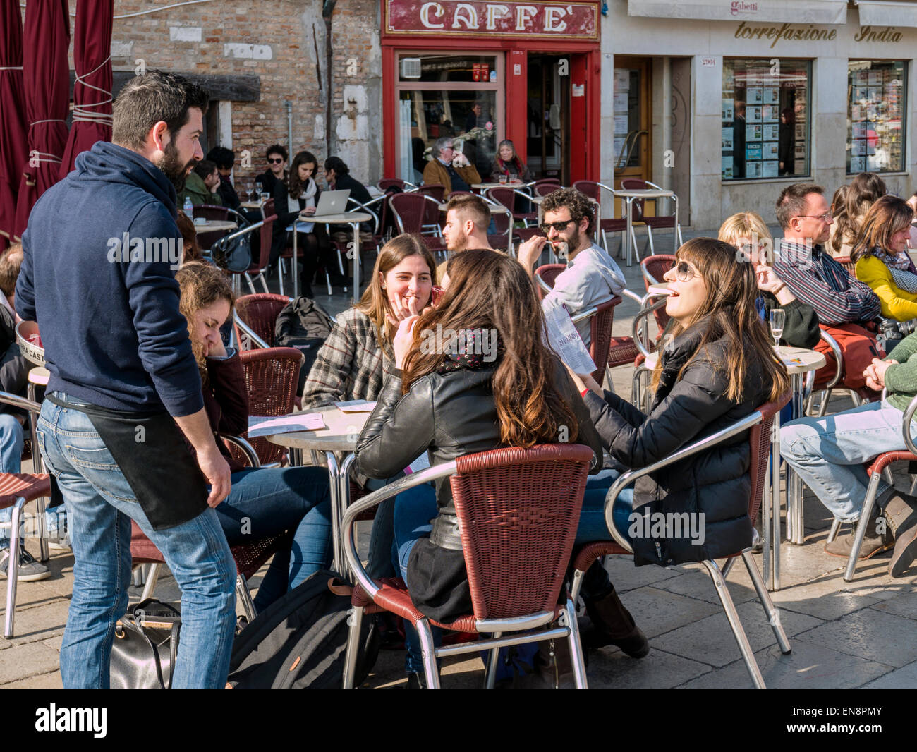 People enjoying food & drink at an outdoor cafe, Venice, Italy Stock Photo