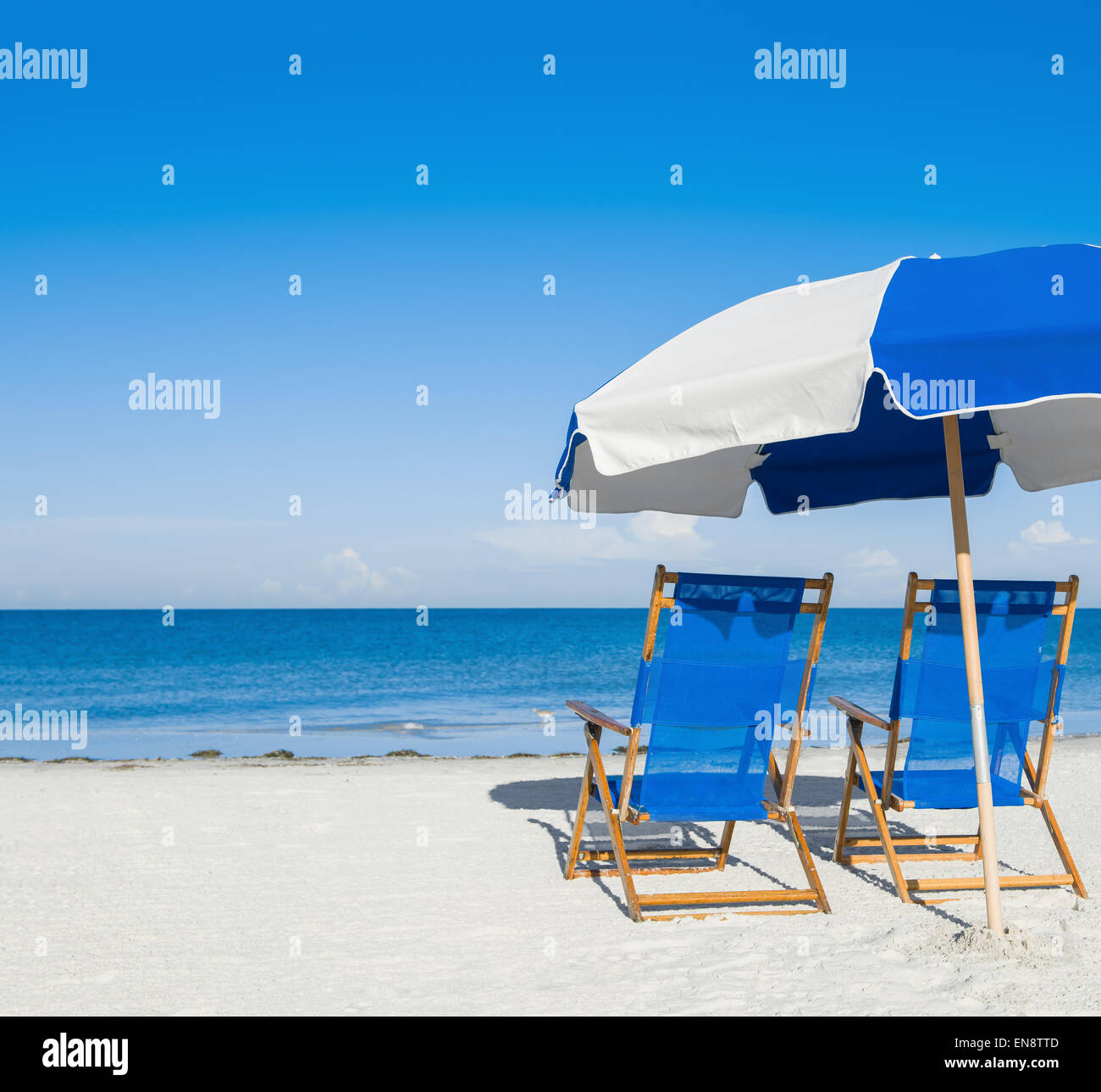 sun loungers and a beach umbrella on silver sand,  vacation concept Stock Photo