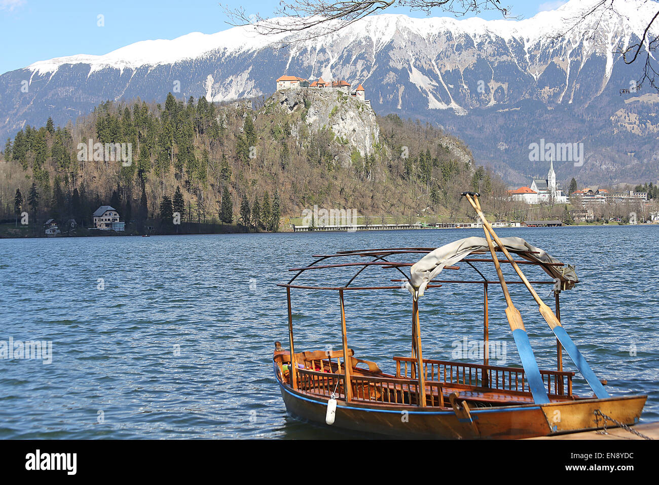 rowboats moored on the shore of Lake Bled and medieval castle in the ...