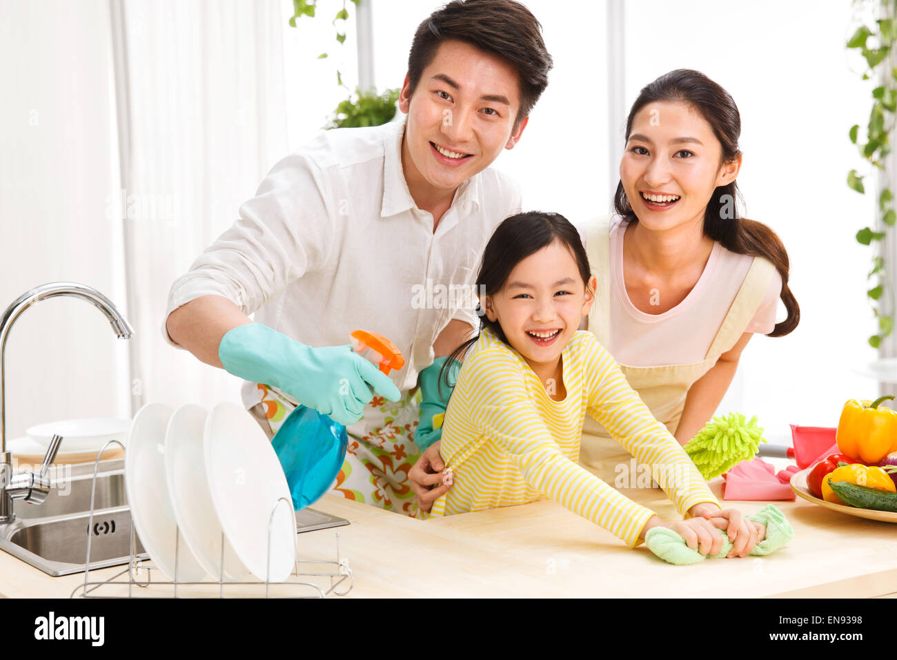 Family doing cleaning-up in kitchen Stock Photo