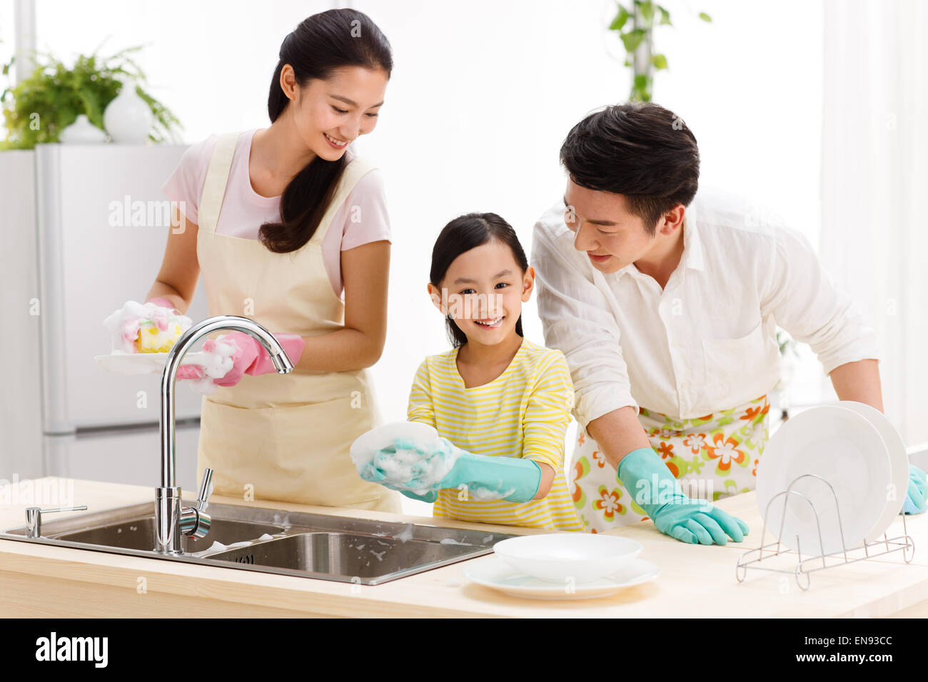 Family doing cleaning-up in kitchen Stock Photo