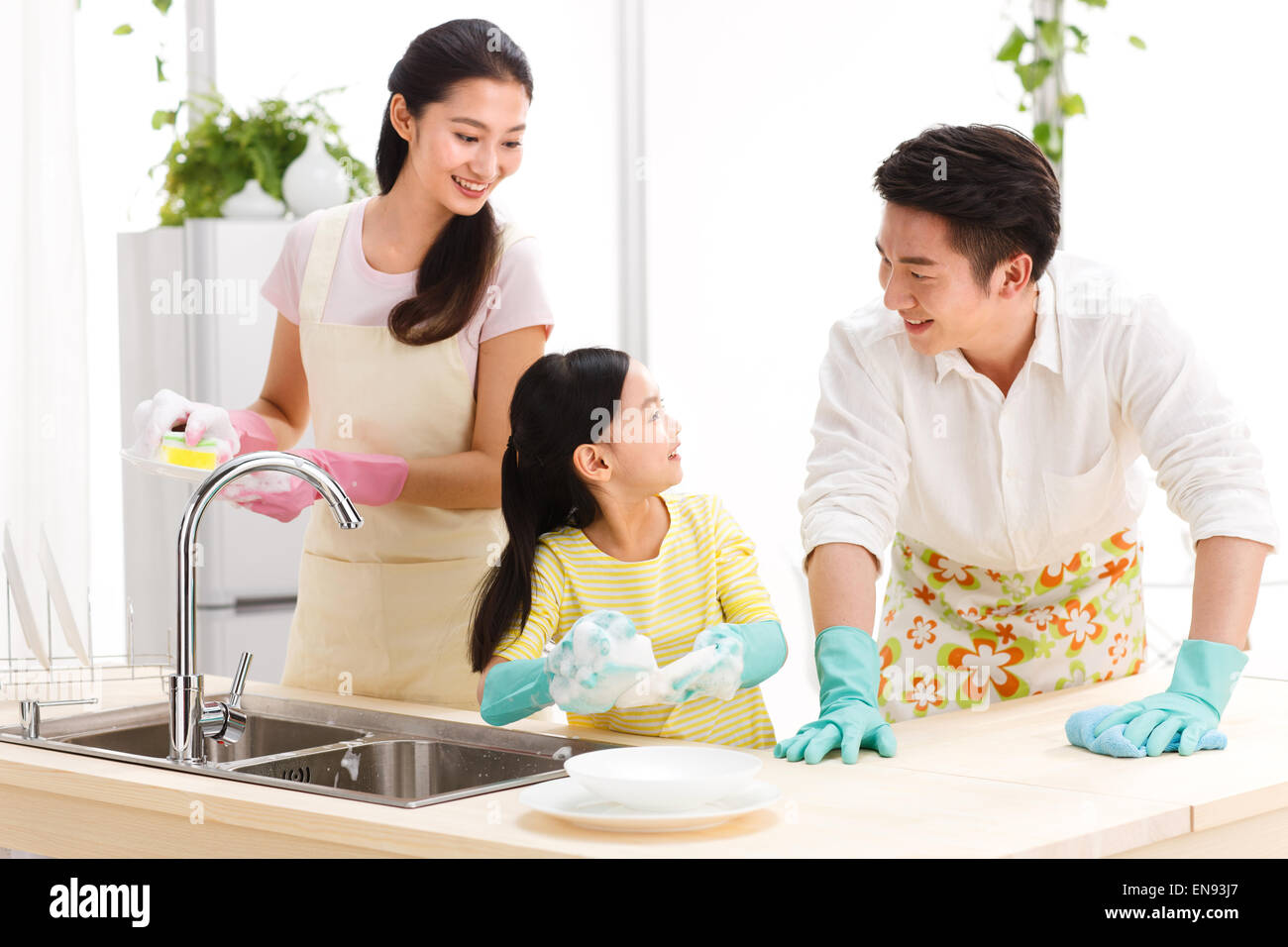Family doing cleaning-up in kitchen Stock Photo