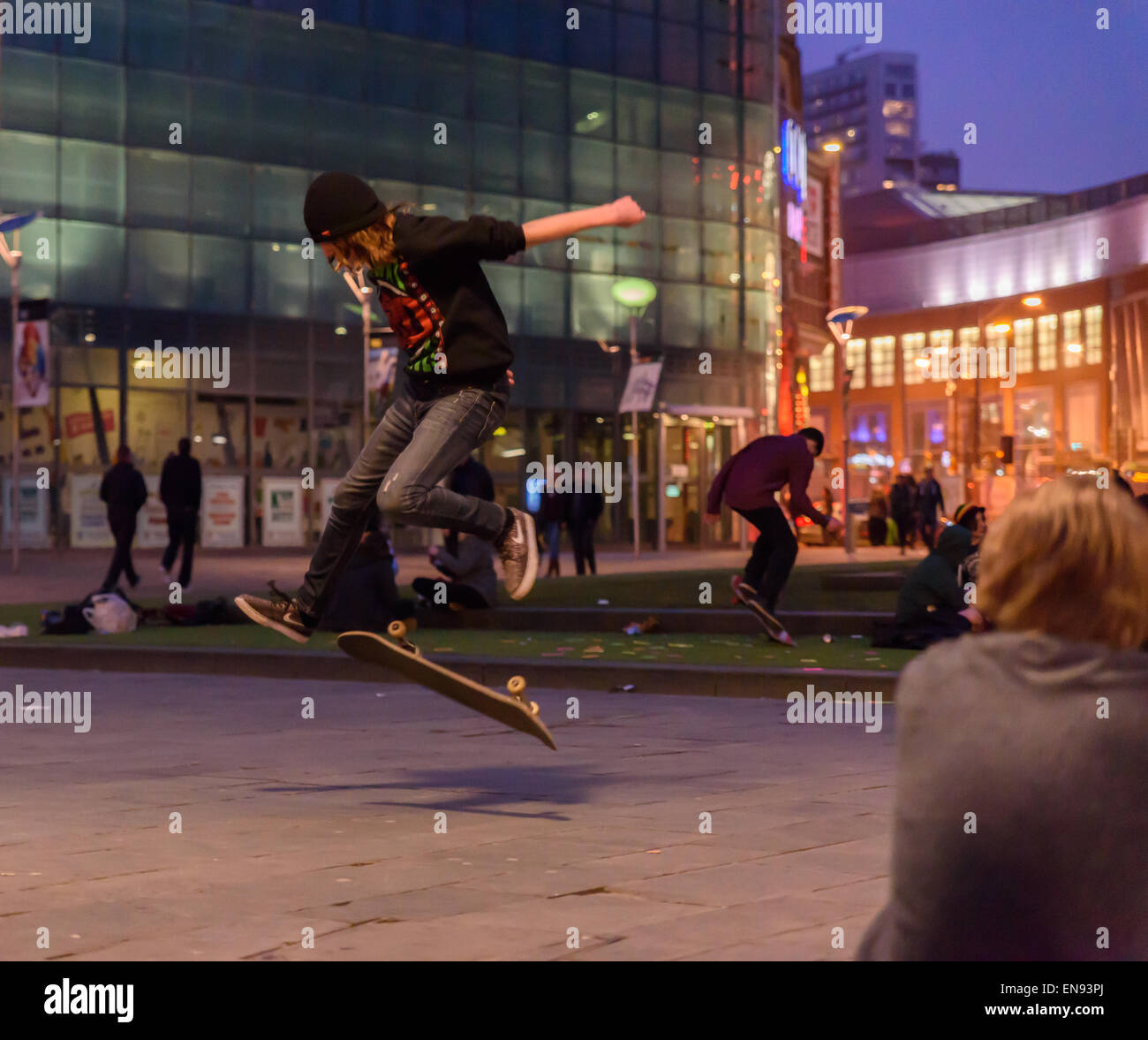 Young people hanging out and skateboarding at Manchester's cathedral gardens, February 2015 Stock Photo