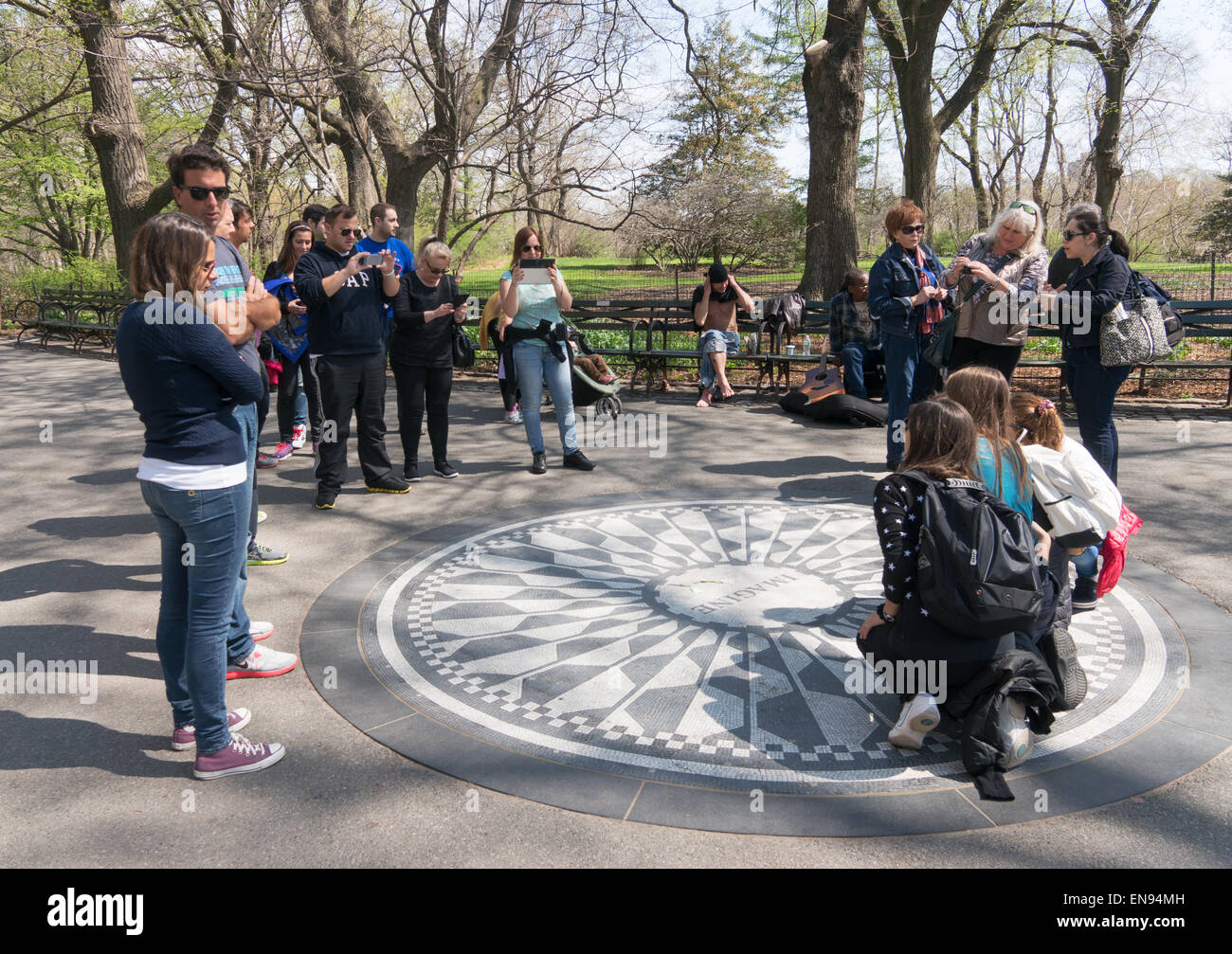 Group of people posing for photograph at the John Lennon, Strawberry Fields, Imagine memorial Central Park, NYC, USA Stock Photo