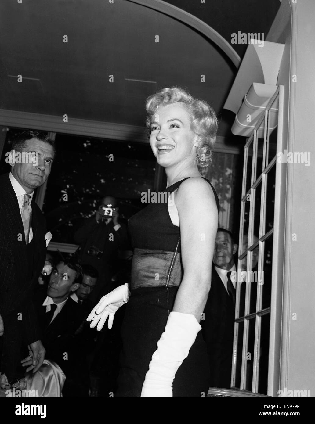 American film actress Marilyn Monroe at the Savoy Hotel during her visit to London to promote her latest film 'The Prince and The showgirl' also starring Laurence Olivier (left). 15th July 1956. Stock Photo