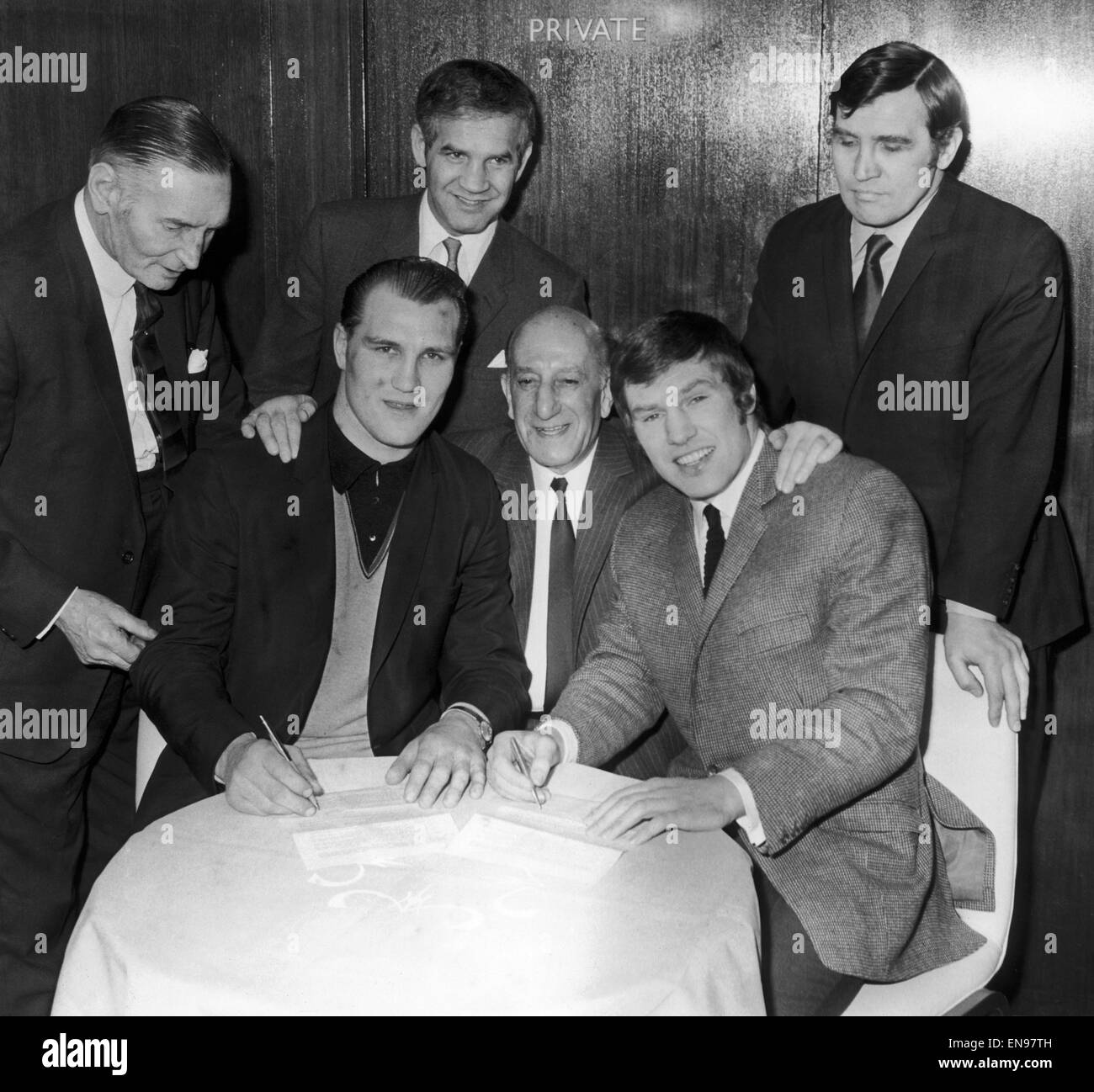 Billy Walker and Jack Bodell, signing contracts at The London Hilton. Behind are Billy's brother George and Harry Levene in the centre. 6th March 1969. Stock Photo