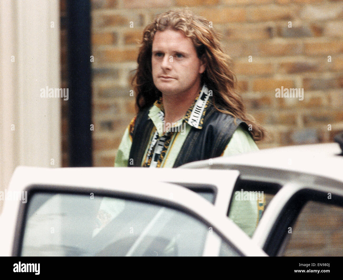 England footballer Paul Gascoigne walks out of a crimper's salon showing off his new hair extensions. 8th August 1993. Stock Photo