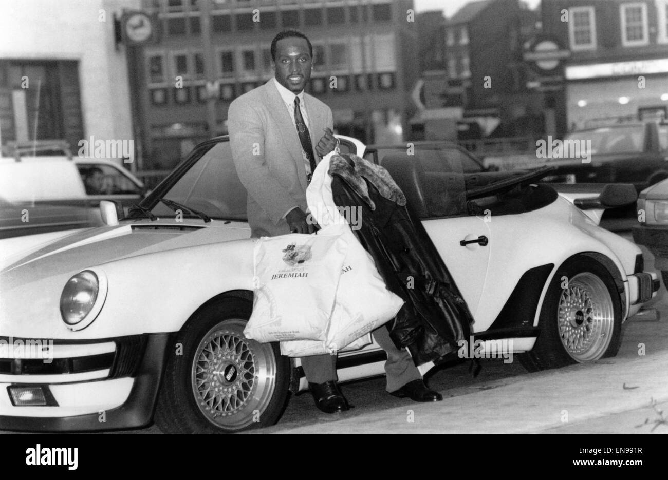 Boxing dandy Nigel Benn breezed through a £1,000-a-minute spending spree yesterday. Nigel is seen here with his purchases and his Ivory-Coloured £100,000 Porsche Turbo. 20th December 1989 P015976 Stock Photo