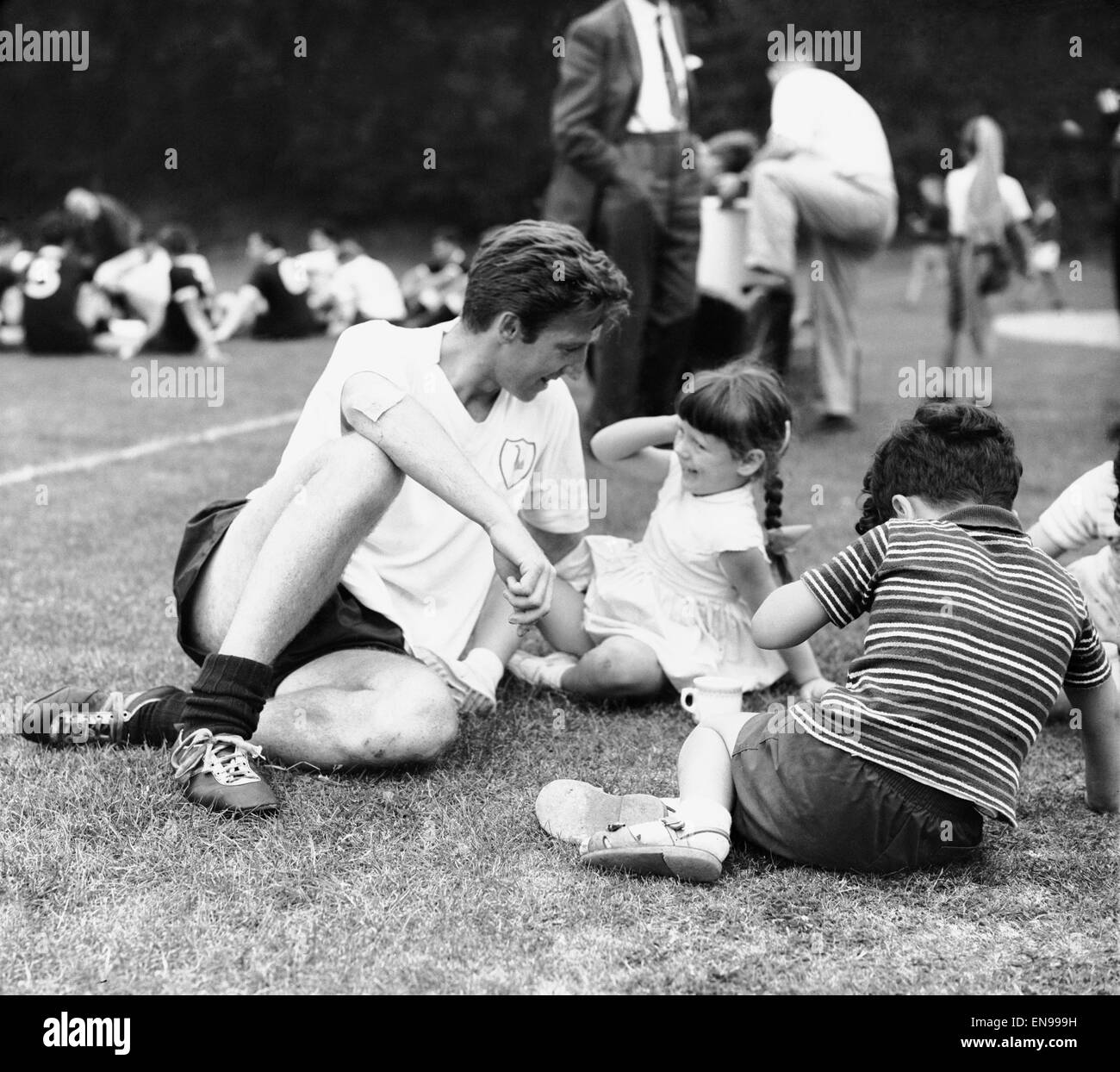 Cliff Jones of Tottenham Hotspur with children during a training session at Cheshunt. 22nd August 1963. Stock Photo