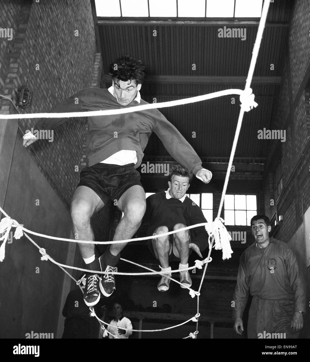 Tottenham Hotspur footballers Ron Henry and Terry Dyson using a rope ladder during a team training session. 10th October 1963. Stock Photo