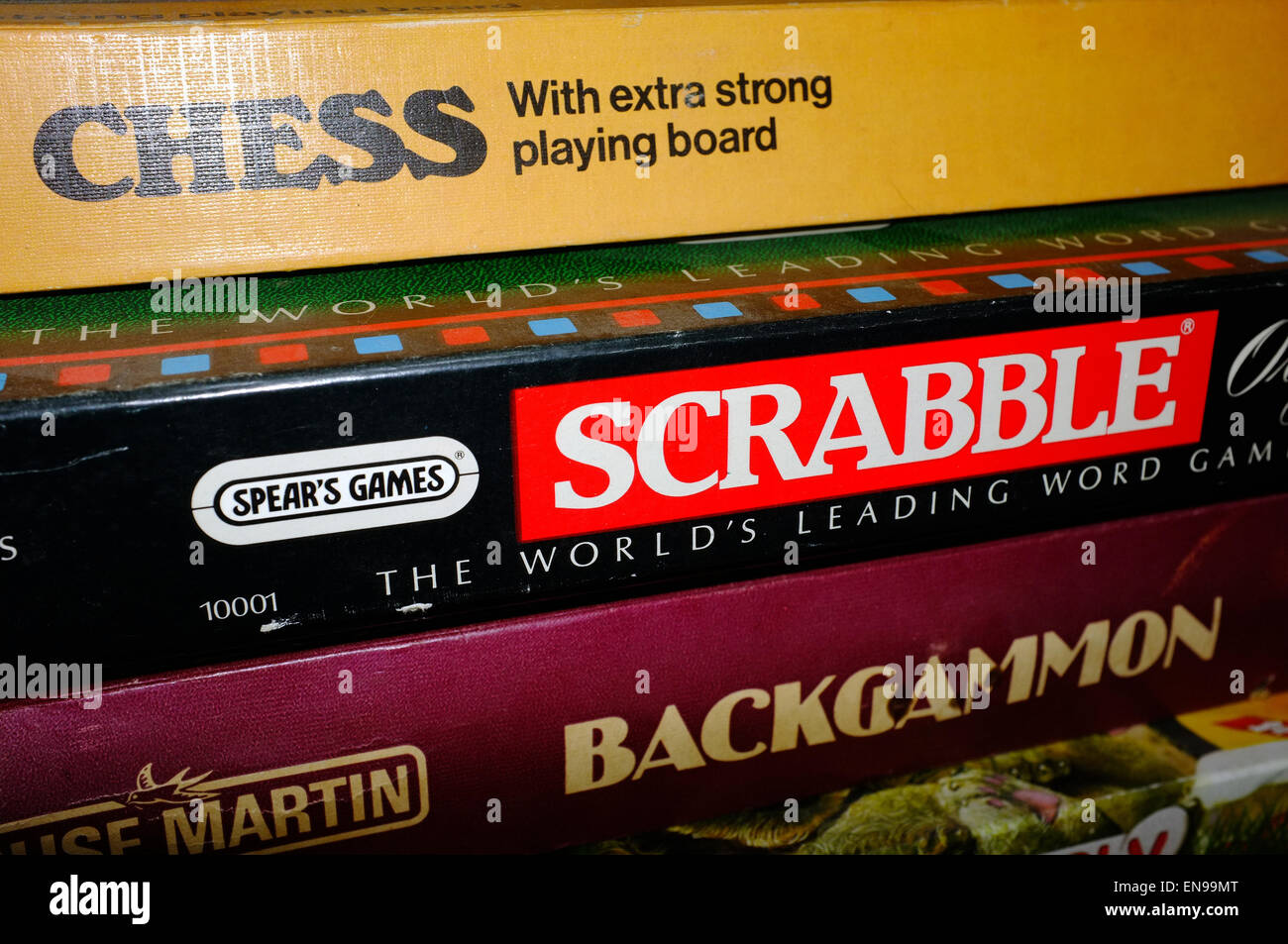 A pile of boardgames boxes including Chess, Scrabble and Backgammon in a Welsh B&B. Stock Photo