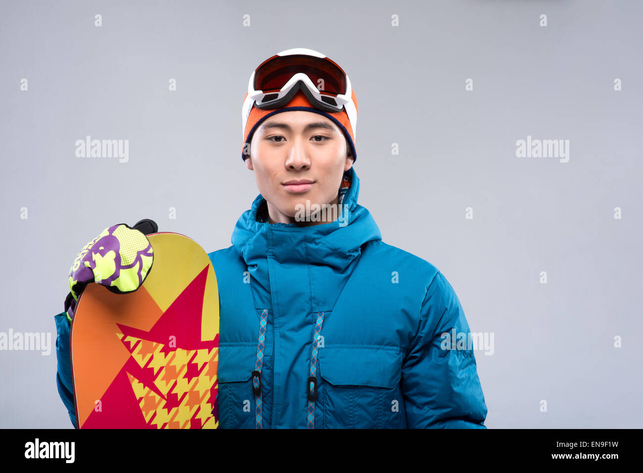 Portrait of a young man holding a snowboard looking at camera Stock ...