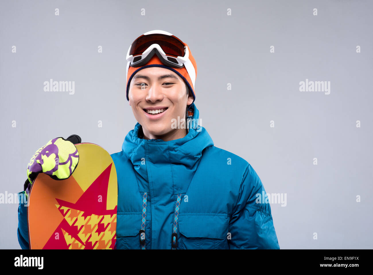 Portrait of a young man holding a snowboard looking at camera Stock Photo