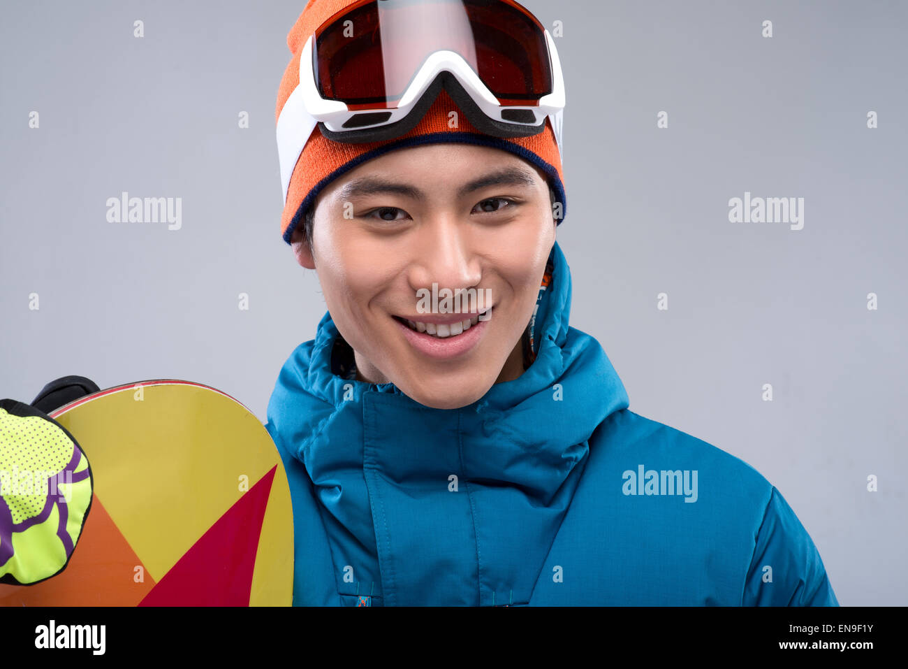 Portrait of a young man holding a snowboard looking at camera Stock ...