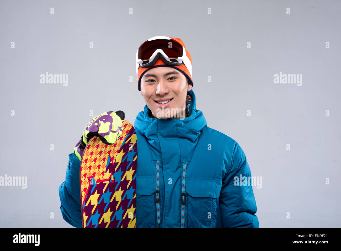 Portrait of a young man holding a snowboard looking at camera Stock ...