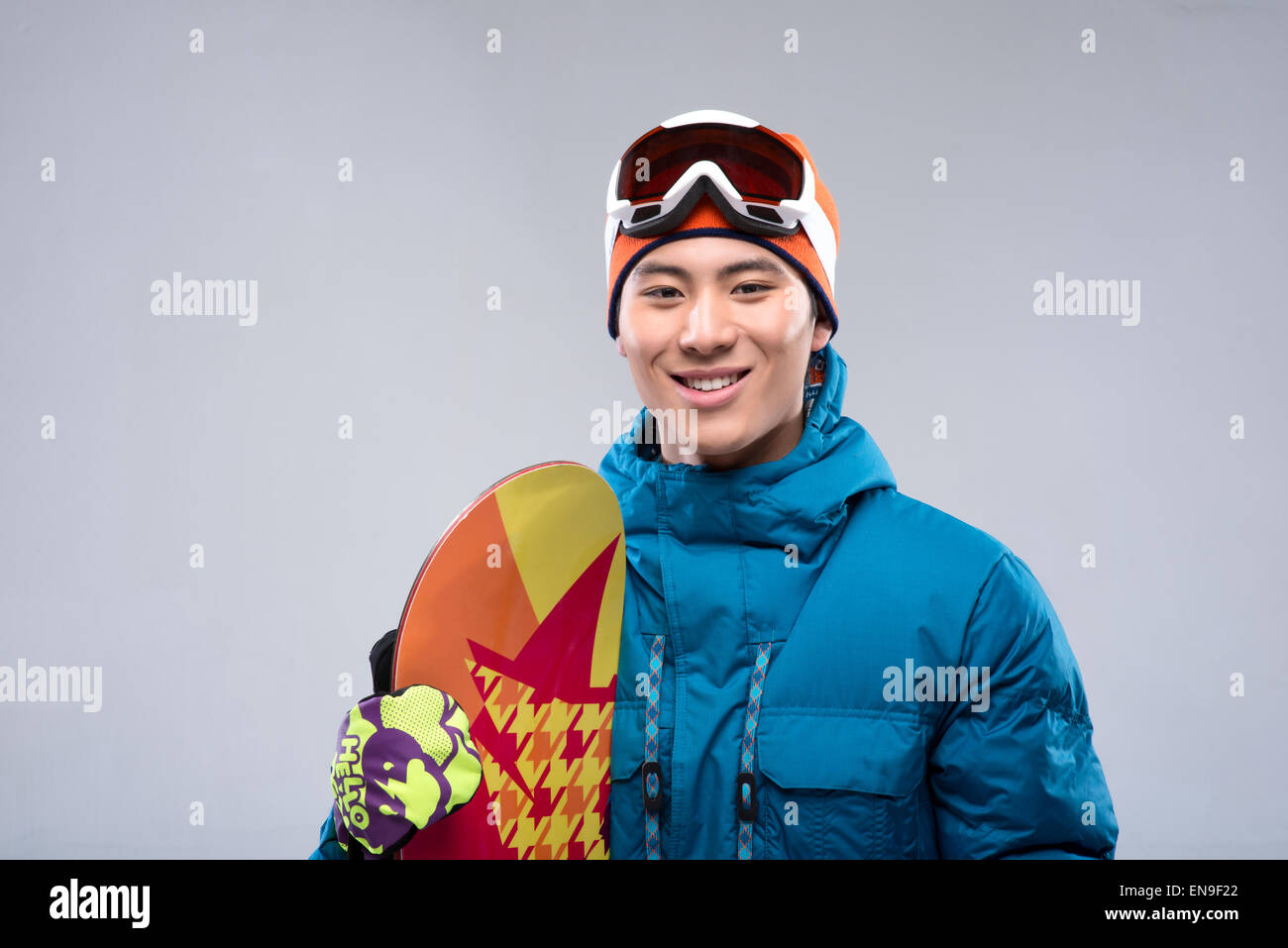Portrait of a young man holding a snowboard looking at camera Stock ...
