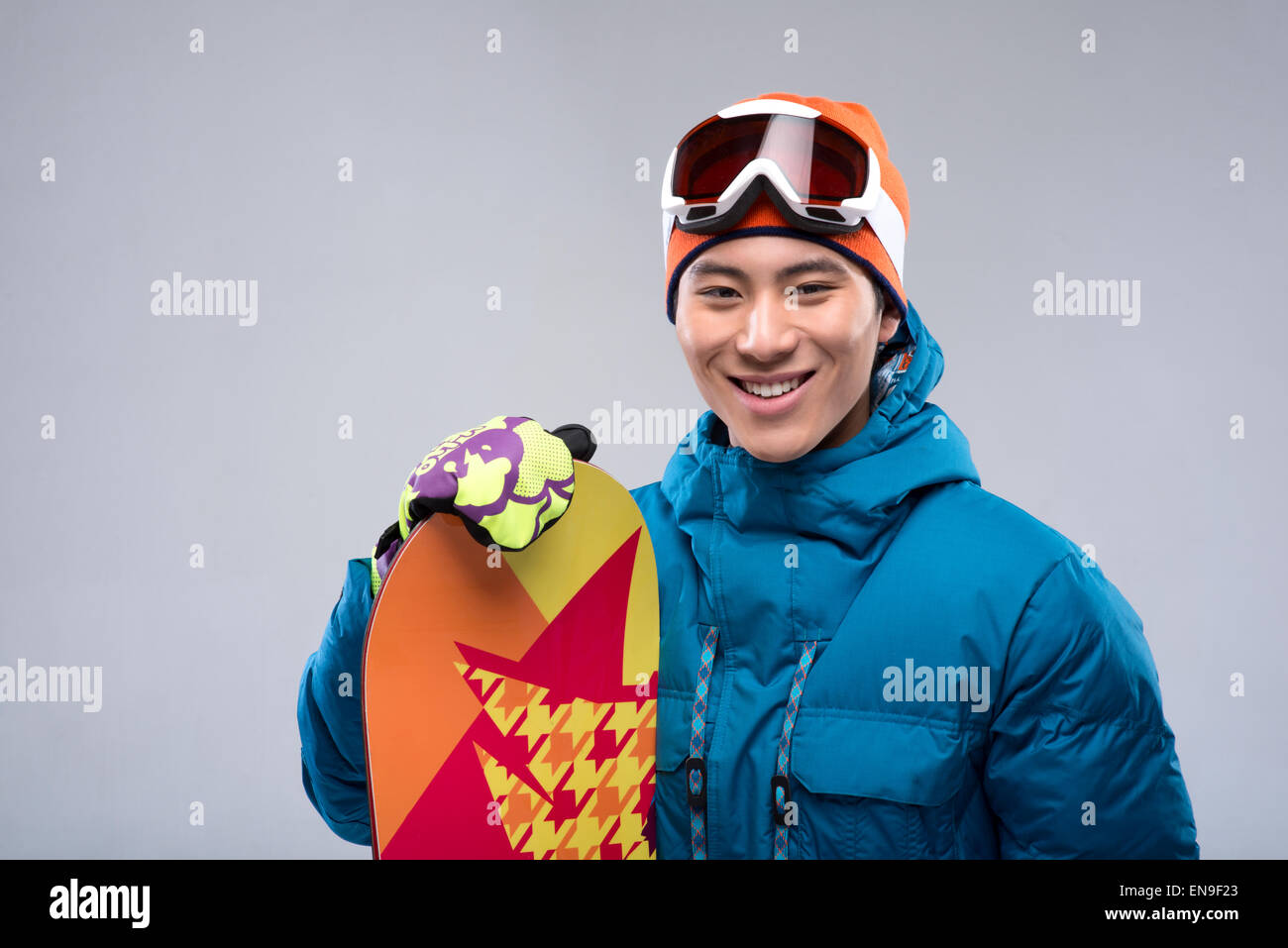 Portrait of a young man holding a snowboard looking at camera Stock ...