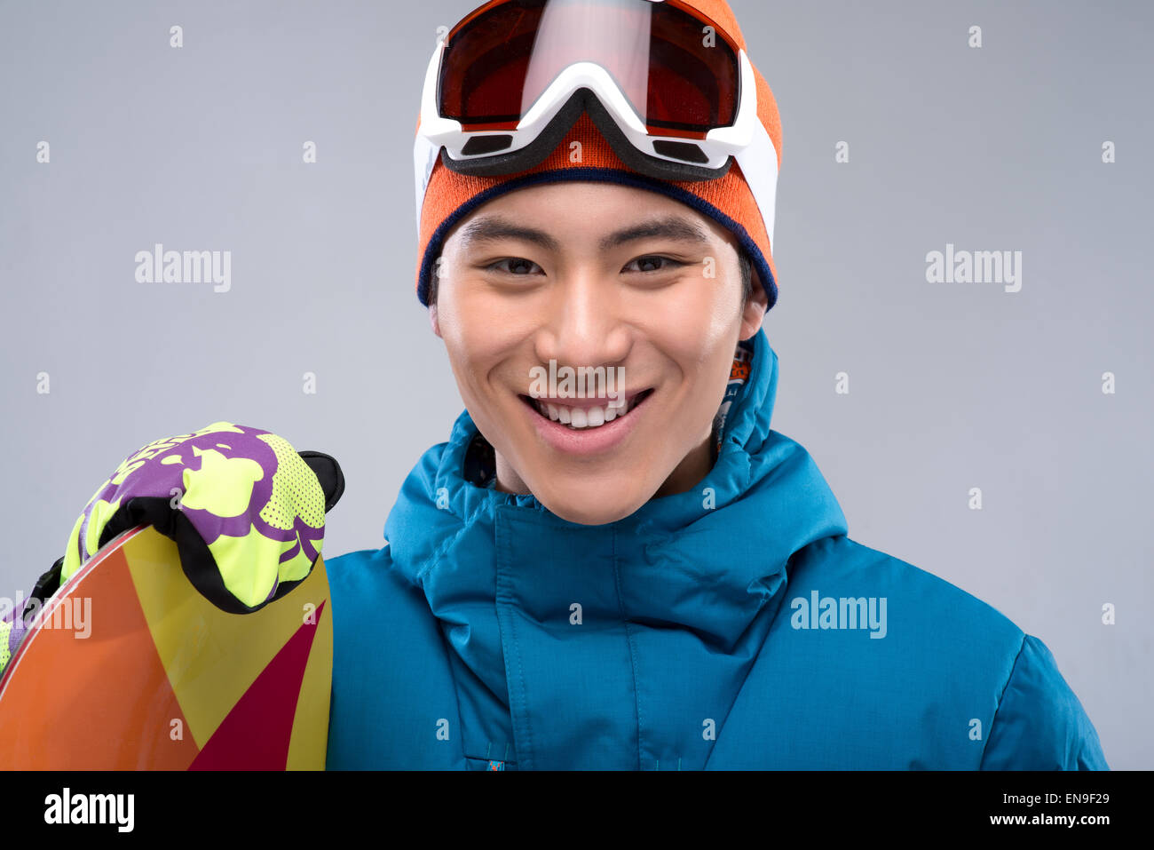 Portrait of a young man holding a snowboard looking at camera Stock ...