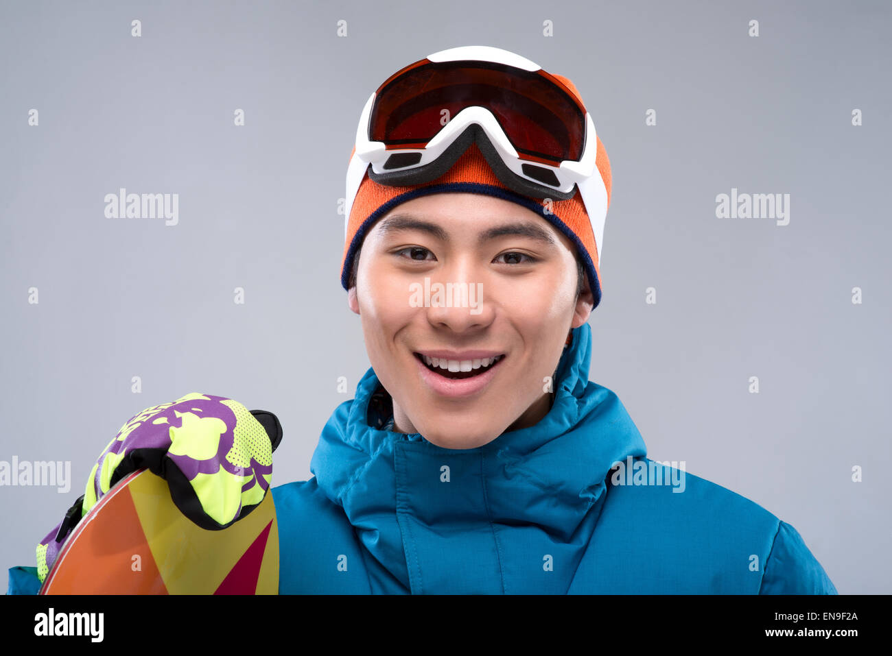 Portrait of a young man holding a snowboard looking at camera Stock ...