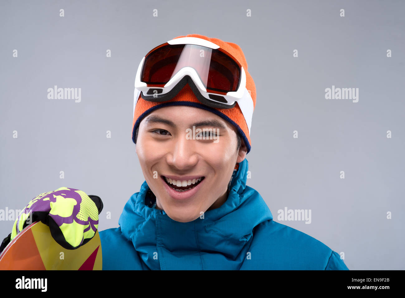 Portrait of a young man holding a snowboard looking at camera Stock ...