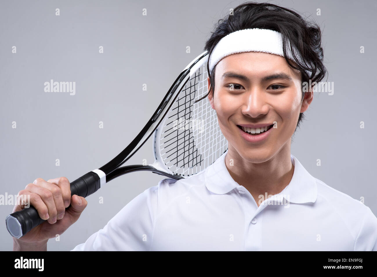 Young man holding tennis racquet on shoulders Stock Photo