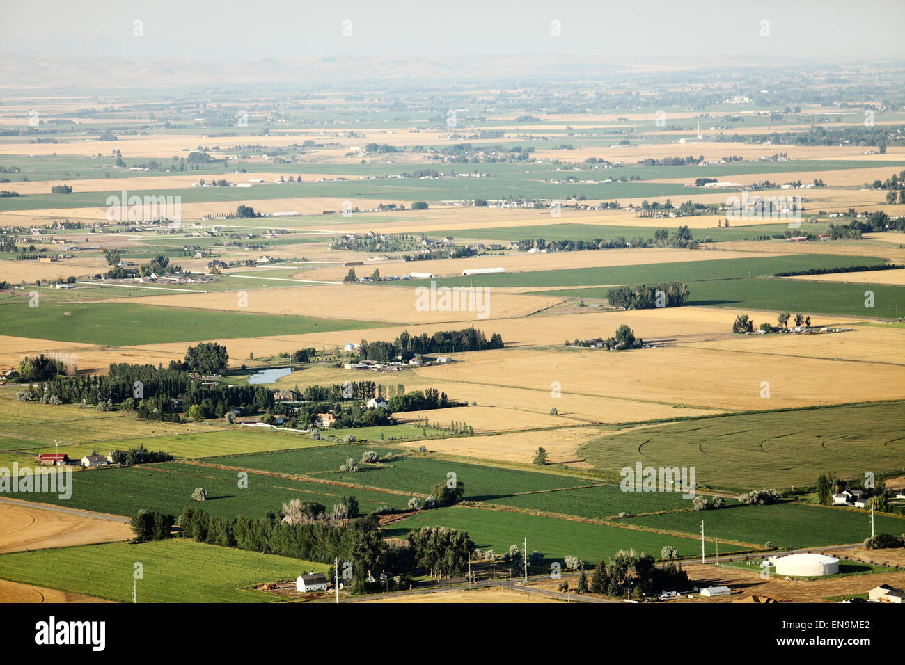 An aerial view of farmland with canals, flood irrigation, and pivot sprinklers watering the fields. Stock Photo