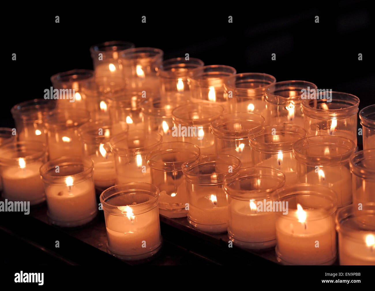 many lit candles to pray inside a church Stock Photo Alamy