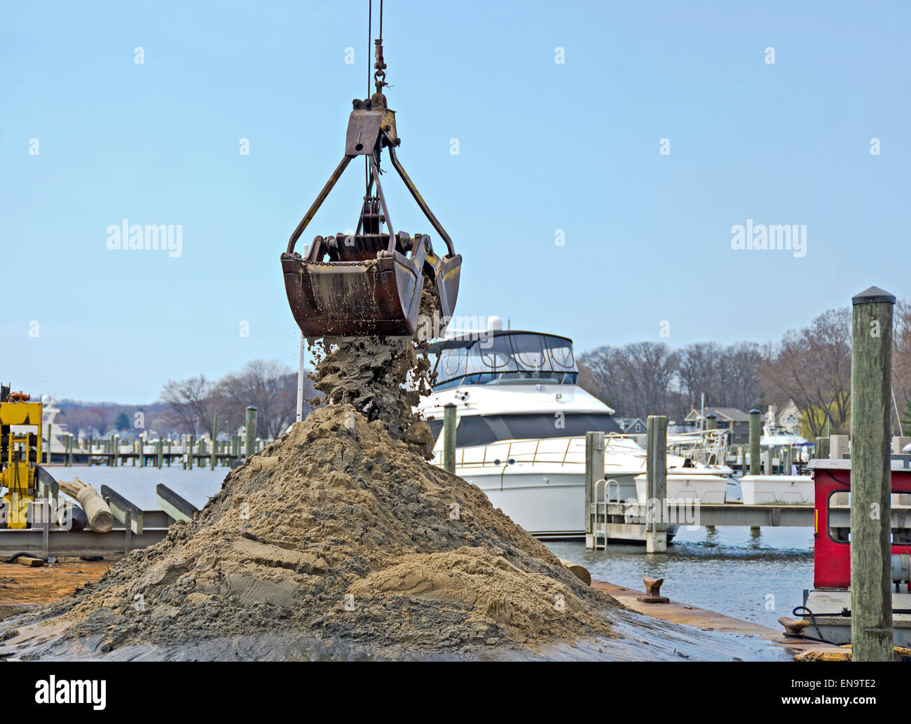 Dredger dredging out a marina slip. Stock Photo