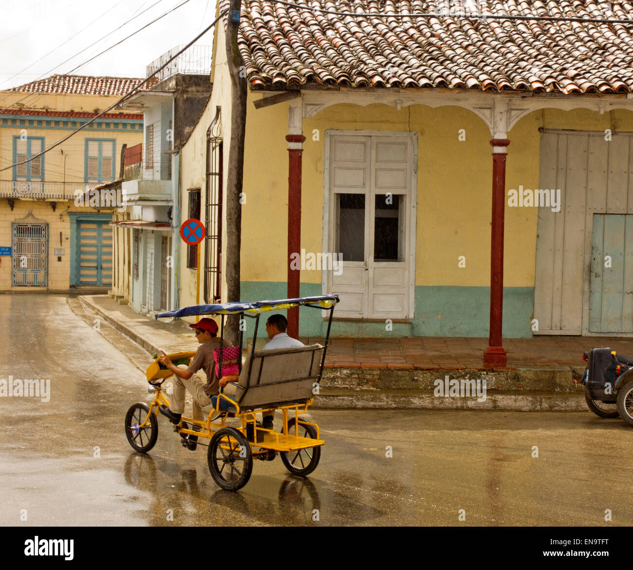 Cuban Bici Taxi pedalling in the rain. Stock Photo