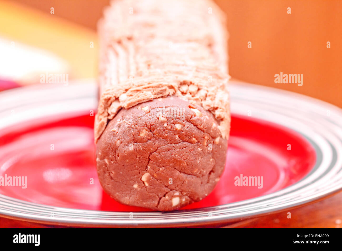 Chocolate dessert log ready-to-eat on red plate Stock Photo