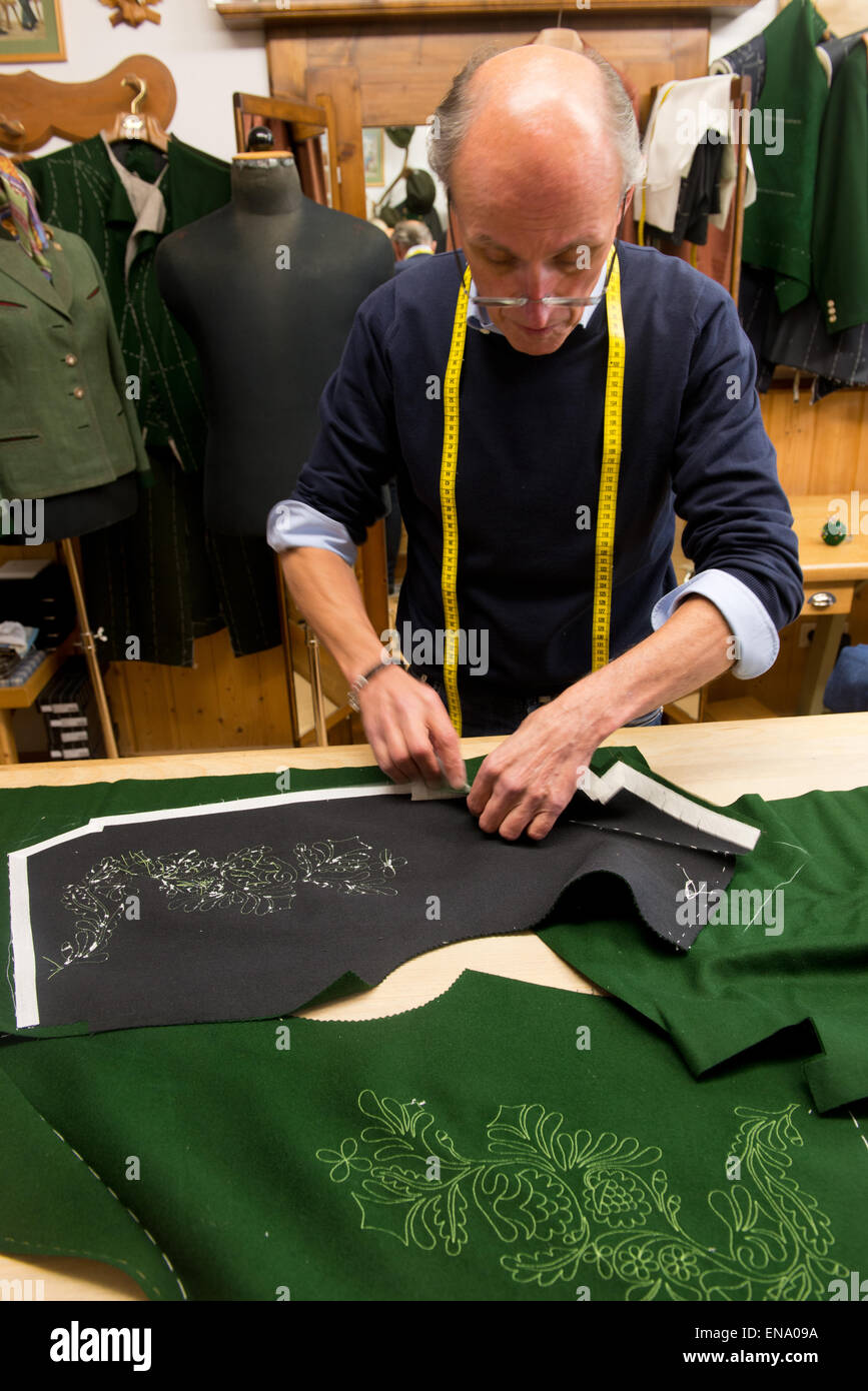 cutting the vest of a green traditional Loden costume in Ausseerland, Bad Aussee, Austria Stock Photo