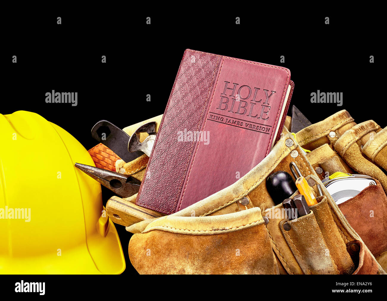 Professional studio photograph of a Bible cover with contractor carpenter construction tool bag and tools and safety helmet Stock Photo