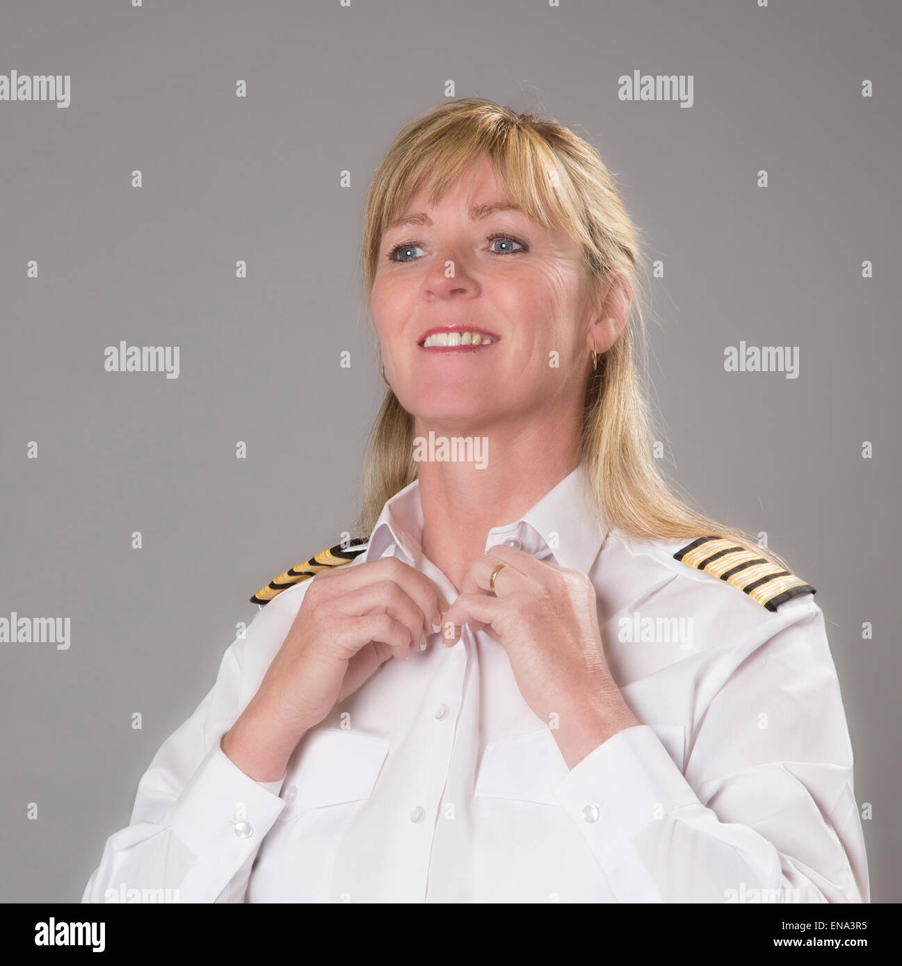 Woman airline officer buttoning white uniform shirt before reporting