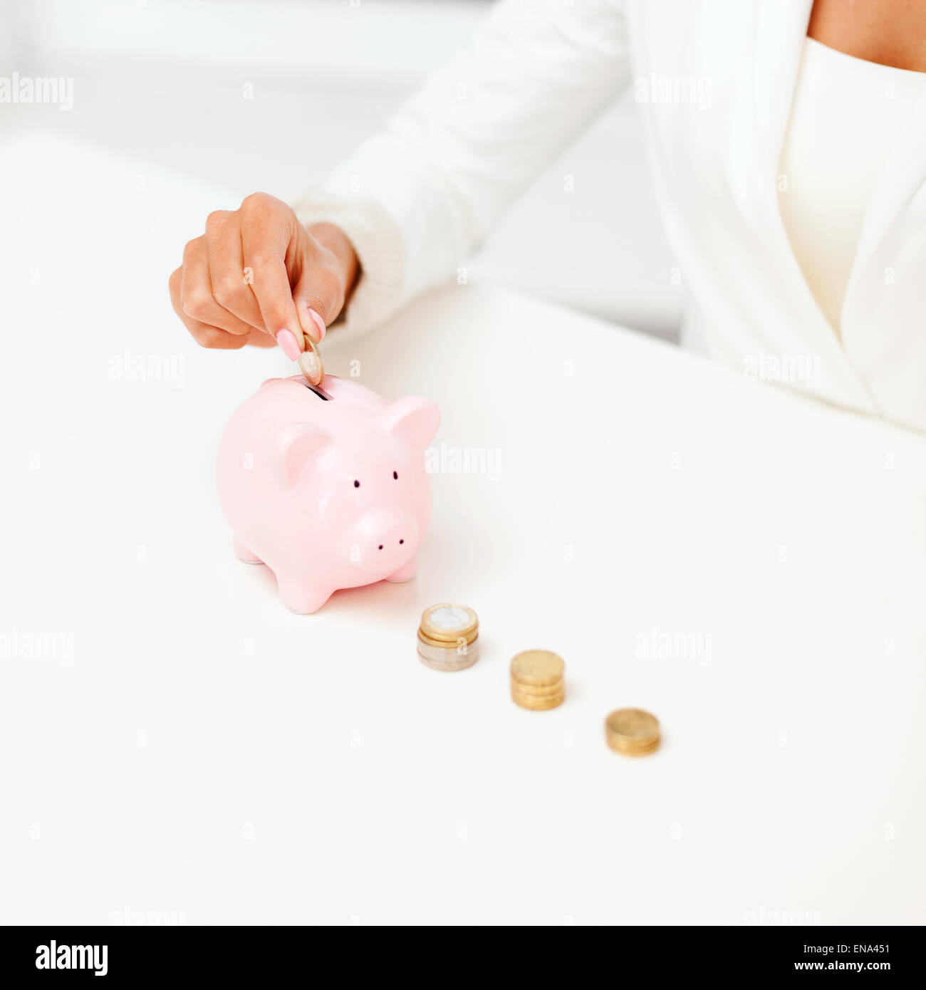 female hand putting euro coins into piggy bank Stock Photo - Alamy
