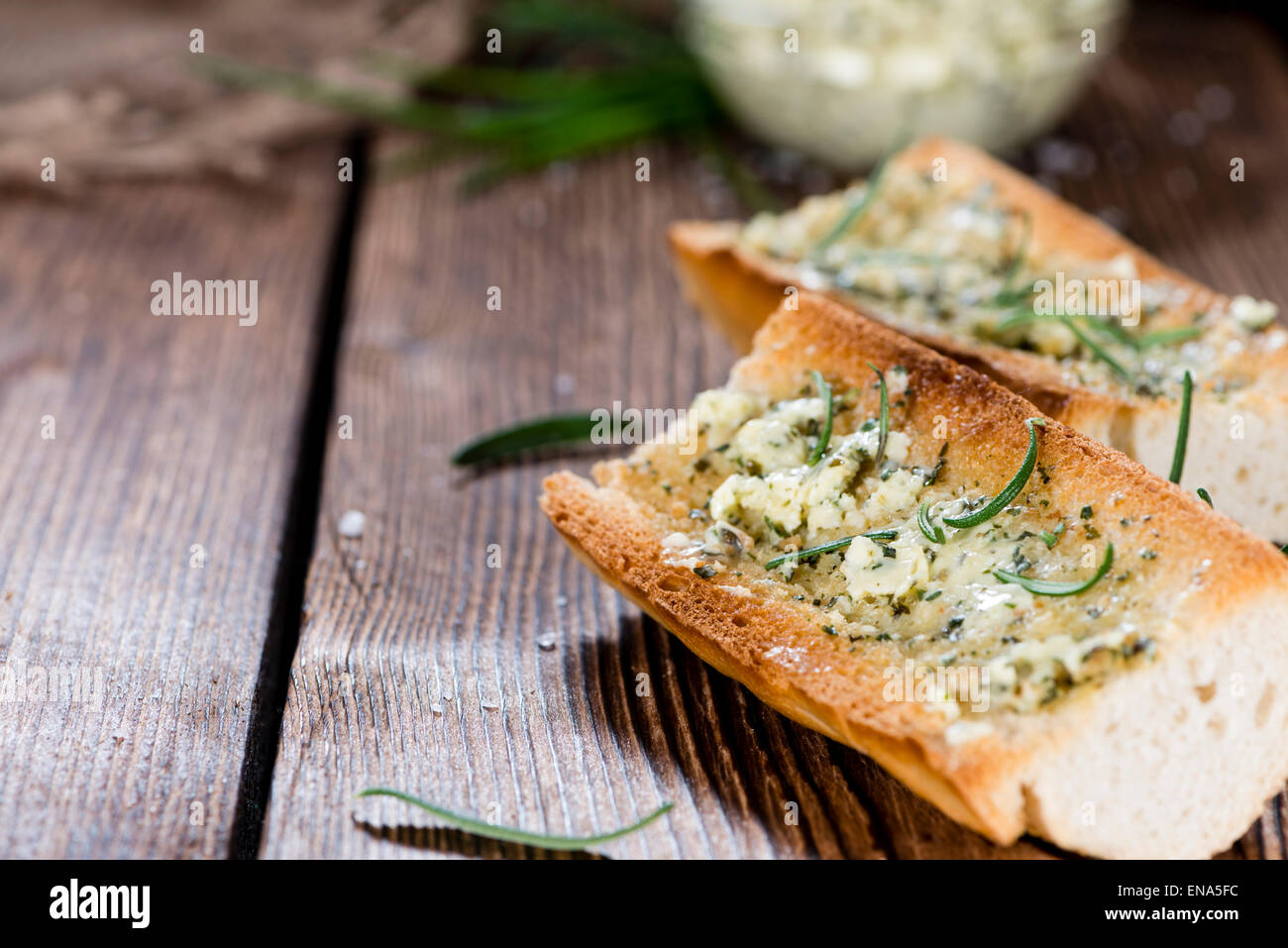 Herb Butter Baguette (detailed closeup shot) on wooden background